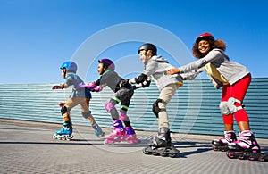 Kids in safety helmets rollerblading on the track