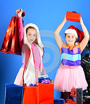 Kids in Santa Claus hats with gift boxes hold presents