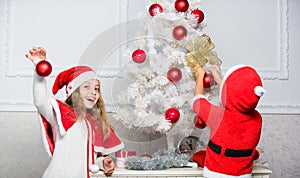 Kids in santa hats decorating christmas tree. Family tradition concept. Children decorating christmas tree together. Boy