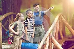 Kids scouts traveler with backpack hiking on bridge