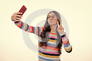 Kids selfie. Funny face. Teenager child girl holding smartphone. Hipster girl with cell phone. Kid hold mobile phone