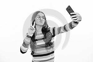 Kids selfie. Funny face. Teenager child girl holding smartphone. Hipster girl with cell phone. Kid hold mobile phone