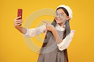 Kids selfie. Teenager child girl holding smartphone. Hipster girl with cell phone. Kid hold mobile phone texting in