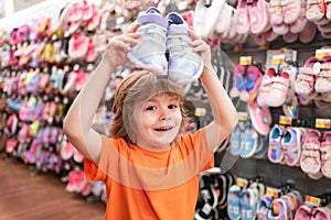 Kids shoes store in supermarket, choosing kids in shoes store. Shoes store for kids. Kid in supermarket shoes shop. Sale