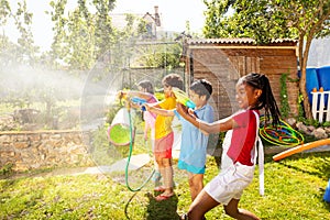Kids shoot with water pistols on summer day