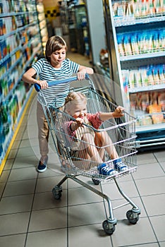 kids with shopping cart in supermarket