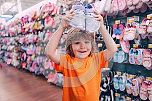 Kids shopping. Sale, consumerism and people concept. Kids shoes store in supermarket, choosing kids in shoes store