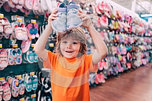 Kids shopping. Sale, consumerism and people concept. Kids shoes store in supermarket, choosing kids in shoes store