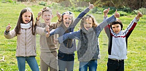 Kids showing thumbs up outdoors