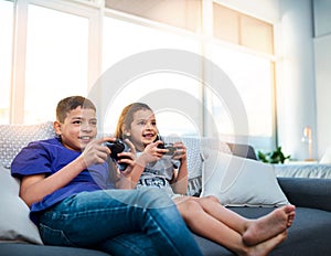 Kids, siblings and video game with controller, sofa and online for esports in home. Technology, entertainment and
