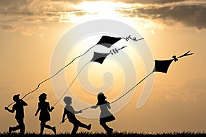 Kids silhouettes playing with kites photo