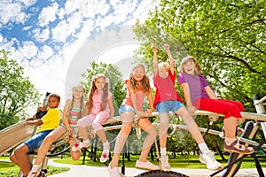 Kids sit on round bar of playground construction