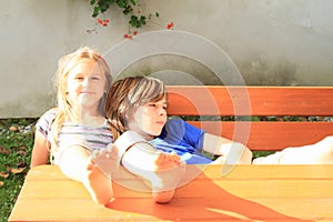 Kids sitting behind wooden table photo