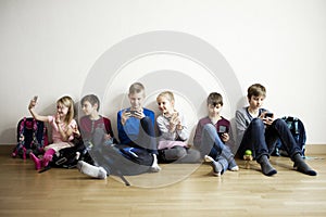 Kids sitting on floor with mobile devices