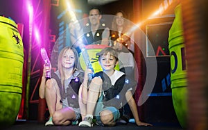 Kids sitting with laser guns in beams