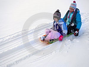 Kids Sledding Down Snow Hill on Sled Fast Speed photo