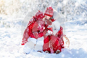 Kids sledding in winter forest. Children drink hot cocoa in snow