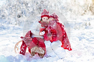 Kids sledding in winter forest. Children drink hot cocoa in snow