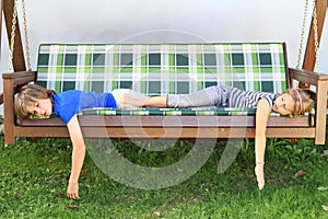 Kids sleeping on a garden swing