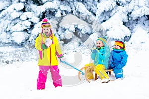 Kids on sleigh ride. Children sledding. Winter snow fun.