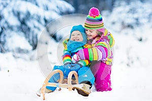 Kids on sleigh ride. Children sledding. Winter snow fun.