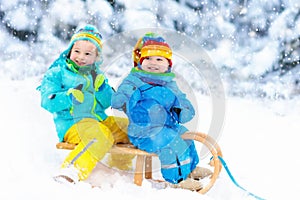 Kids on sleigh ride. Children sledding. Winter snow fun.