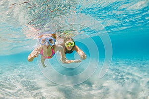 Kids in snorkeling mask dive underwater in blue sea lagoon