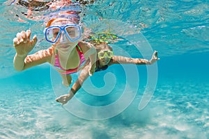 Kids in snorkeling mask dive underwater in blue sea lagoon