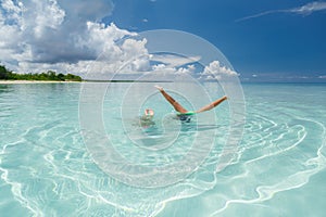 Kids snorkeling, playing and having fun in tranquil turquoise beautiful ocean on sunny beautiful day