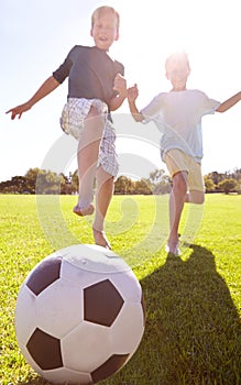 Kids, soccer ball and field outdoor with fun, bonding and summer play with smile from sport. Running, happy and game
