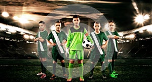 Kids - soccer champions. Boys in football sportswear on stadium with ball. Sport concept with soccer team.