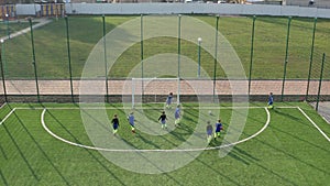 Kids soccer team playing on green football field