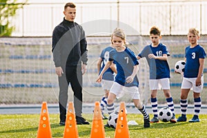 Kids in soccer team on practice session with young coach