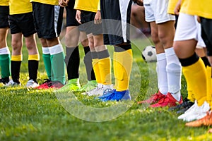 Kids on soccer training. Soccer players standing in a row. Low angle image of footballer`s legs in a sportswear and cleats