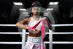 Kids sport concept. Girl sportsman muay thai boxer fighting in gloves in boxing gym.