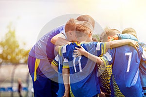 Kids sport team having pep talk with coach. Children soccer team motivated by trainer. Coaching football youth team