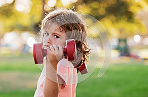 Kids sporty lifestyle. Boy workout with dumbbell in park. Kid sport. Child exercising outdoor.