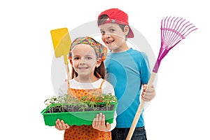 Kids with spring seedlings and gardening tools