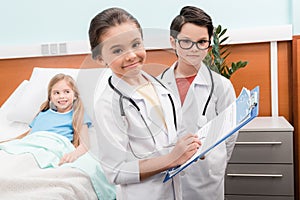 Kids with stethoscopes playing doctors photo