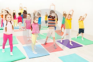 Kids stretching during gymnastic lesson in gym