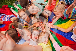 Kids at summer day camp, happily resting on a ground