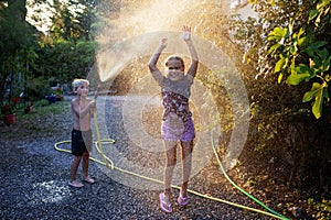 Kids summer fun with water spray, happy childhood, vacations