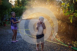 Kids summer fun with water spray, happy childhood, vacations