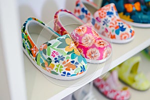 kids summer shoes with fun patterns on shelf