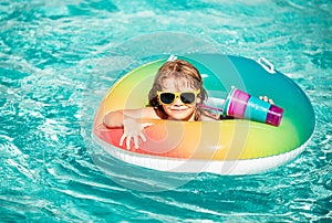 Kids summer vacation. Summertime kids weekend. Boy in swiming pool. Child at aquapark on inflatable rubber circle.