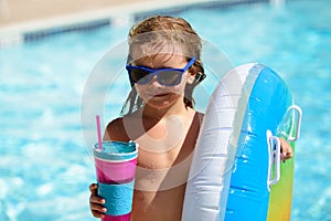 Kids summer vacation. Summertime weekend. Boy in swiming pool. Child at aquapark. Funny boy on inflatable rubber circle.