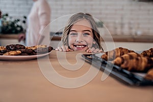 Kids and sweets. Naughty little girl going to steal some cookies, kitchen interior, copy space