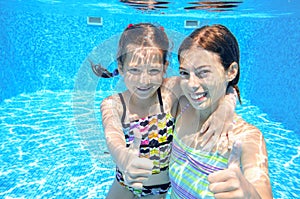 Kids swim in pool underwater