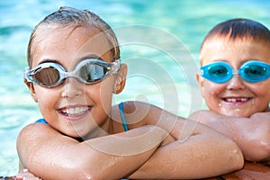 Kids in swimming pool with goggles.