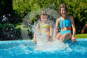 Kids in swimming pool have fun and splash in water